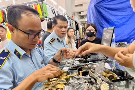 Cán bộ Cục Quản lý và Phát triển thị trường trong nước trực tiếp kiểm tra những "điểm nóng" về buôn lậu, hàng giả. (Ảnh: PV/Vietnam+)