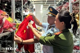 Một số lượng lớn quần áo mang nhãn hiệu NIKE, ADIDAS, PUMA bị lực lượng chức năng phát hiện. (Ảnh: TTXVN phát) 