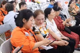 Nhân viên EVNHANOI hướng dẫn khách hàng sử dụng App để theo dõi lượng điện tiêu thụ. (Ảnh: evnhanoi)