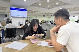 Người dân làm thủ tục về đất đai tại Trung tâm Phục vụ hành chính công Hà Nội. (Ảnh: Xuân Quảng/Vietnam+)