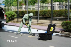 Lực lượng chức năng tiến hành thu hồi nguồn phóng xạ. (Ảnh: Thu Hoài/TTXVN)