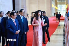 Thủ tướng Phạm Minh Chính và Thủ tướng Lào Sonexay Siphandone tham quan trưng bày ảnh về quan hệ hợp tác giữa hai nước do Thông tấn xã Việt Nam thực hiện. (Ảnh: Dương Giang/TTXVN)