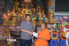 Đồng chí Y Thông, Thứ trưởng Bộ Dân tộc và Tôn giáo tặng quà đến Hòa thượng Dương Quân, Phó Chủ tịch Hội Đoàn kết sư sãi yêu nước tỉnh Cà Mau nhân chuyến thăm, chúc mừng Tết Chôl Chnăm Thmây tại Cà Mau. (Ảnh: Chanh Đa/TTXVN)