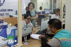 Cán bộ, công chức tận tình giải đáp thắc mắc, hỗ trợ giải quyết hồ sơ cho nhân dân tại Điểm phục vụ Hành chính công Hai Bà Trưng, Hà Nội. (Ảnh: Vũ Quang/TTXVN)