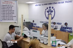 Người dân được cán bộ, công chức hỗ trợ giải quyết hồ sơ tại Điểm phục vụ Hành chính công phường Hai Bà Trưng (Hà Nội). (Ảnh: Vũ Quang/TTXVN)