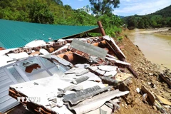 Ngôi nhà của người Ơ Đu nằm bên bờ suối Nậm Ngân bị lũ cuốn trôi và đổ sập xuống suối. (Ảnh: Xuân Tiến/TTXVN)