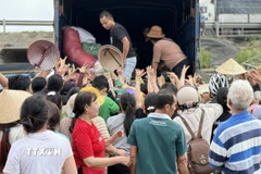 Người dân vùng lũ tỉnh Đắk Lắk nhận hàng cứu trợ. (Ảnh: Tường Quân/TTXVN)