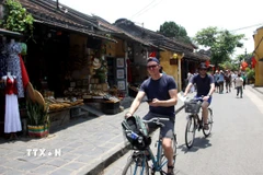 Khách quốc tế đạp xe tham quan, trải nghiệm tại các tuyến phố cổ ở thành phố Hội An (Quảng Nam). (Ảnh: Trịnh Bang Nhiệm/TTXVN)