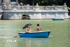 Người dân đi thuyền trên sông trong ngày nắng nóng tại Madrid, Tây Ban Nha. (Ảnh: THX/TTXVN)