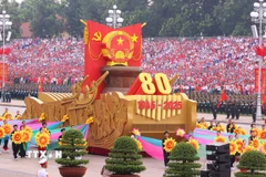 Xe mô hình Quốc huy nước Cộng hòa xã hội chủ nghĩa Việt Nam đi đầu khối diễu binh, diễu hành. (Ảnh: TTXVN)