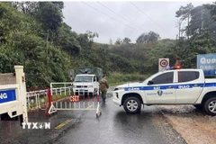 Lực lượng chức năng chốt chặn không cho người và phương tiện qua lại nơi sạt lở trên đèo Ngoạn Mục. (Ảnh: TTXVN phát)