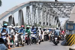 Người dân mặc đồ bảo hộ chống nắng nóng khi tham gia giao thông trên cầu Trường Tiền, thành phố Huế. (Ảnh: Nguyên Lý/TTXVN)