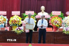 Phó Chủ tịch Ủy ban Nhân dân thành phố Cần Thơ Trần Chí Hùng trao Bằng khen của Chủ tịch Ủy ban Nhân dân thành phố cho Anh hùng lao động, kỹ sư Hồ Quang Cua. (Ảnh: Thanh Liêm/TTXVN)