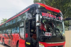 Cảnh sát dừng xe kiểm tra xe khách nhồi nhét khách. (Ảnh: TTXVN phát)