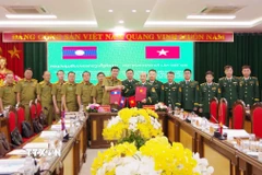 Đại tá Vừ A Khua, Phó Chỉ huy trưởng Ban Chỉ huy Bộ đội Biên phòng tỉnh Điện Biên và Đại tá Pạ Sợt Phổn Mạ Lắt, Phó Giám đốc Ty An ninh tỉnh Luang Prabang trao biên bản ghi nhớ hội đàm. (Ảnh: TTXVN phát)