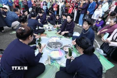 Thi gói bánh chưng đen. (Ảnh: Anh Tuấn/TTXVN)