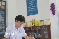 Đoàn Thanh Tùng học tập tại thư viện nhà trường. (Ảnh: Phan Sáu/TTXVN)