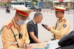 Cán bộ, chiến sỹ đội Cảnh sát Giao thông số 6 kiểm tra nồng độ cồn đối với tài xế xe khách. (Ảnh: Phạm Kiên/TTXVN)