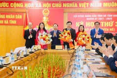 Tặng hoa chúc mừng các đồng chí được bầu vào chức danh lãnh đạo mới của Hội đồng Nhân dân và Ủy ban Nhân dân tỉnh. (Ảnh: TTXVN phát)