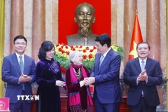 Chủ tịch nước Lương Cường thăm hỏi y tá Nguyễn Thị Kim Lai - nhân vật “O du kích nhỏ” trong tác phẩm ảnh đen trắng của nhà báo Phan Thoan. (Ảnh: Lâm Khánh/TTXVN)