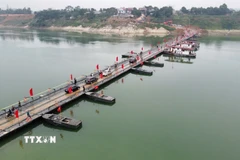 Người và phương tiện lưu thông bình thường qua cầu phao sông Lô sáng 16/2. (Ảnh: Nguyễn Văn Cảnh/TTXVN)