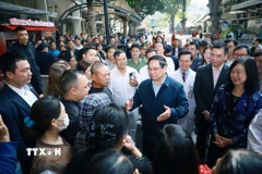 Thủ tướng Phạm Minh Chính thăm hỏi, chúc Tết người thân bệnh nhân điều trị tại Bệnh viện Bạch Mai. (Ảnh: Dương Giang/TTXVN)