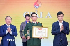 Đồng chí Bùi Quang Huy, Ủy viên dự khuyết Ban Chấp hành Trung ương Đảng, Bí thư thứ nhất Ban Chấp hành Trung ương Đoàn, Trưởng Ban Chỉ đạo 35 Trung ương Đoàn trao giải A cho tác giả. (Ảnh: Minh Đức/TTXVN)