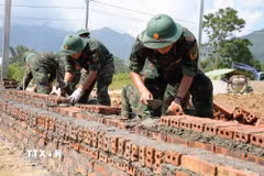 Các chiến sỹ Bộ chỉ huy Quân sự tỉnh Lai Châu tập trung xây nhà cho người dân vùng lũ Mường Than. (Ảnh: Nguyễn Oanh/TTXVN)
