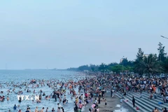 Dọc bờ biển Cửa Lò trong xanh kéo dài gần 10km đông nghịt người. (Ảnh: Bích Huệ/TTXVN)