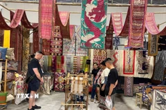 Du khách tham quan, mua sắm các sản phẩm dệt thổ cẩm Hoa Tien Brocade. (Ảnh: TTXVN phát)