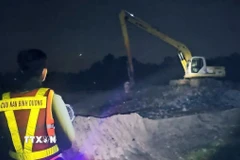 Các lực lượng chức năng tìm kiếm tung tích nạn nhân. (Ảnh: TTXVN phát)