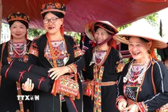 Phụ nữ dân tộc lựa chọn trang phục, phụ kiện truyền thống tại Lễ hội Chợ Thụt, xã Phù Lưu (Tuyên Quang). (Ảnh: Minh Tâm/TTXVN)