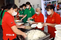 Các thành viên Hội Cơm tình nguyện (phường Thiên Trường) và học sinh trường THPT Nguyễn Khuyến (phường Nam Định) chuẩn bị các suất cơm miễn phí trao tặng người bệnh. (Ảnh: Nguyễn Lành/TTXVN)