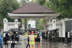 Lực lượng cảnh sát giao thông làm nhiệm vụ điều tiết giao thông trước cửa nhà tang lễ. (Ảnh: Quốc Lũy/TTXVN)