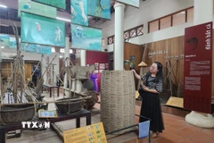 Du khách tham quan nhà trưng bày nông cụ thuộc Điểm du lịch giảm nhựa Cầu ngói Thanh Toàn. (Ảnh: Mai Trang/TTXVN)