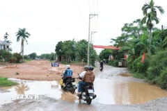 Khi trời mưa đường dẫn lên cầu An Mô mới có nhiều vũng nước đọng, nhiều chỗ bùn đất lầy lội gây khó khăn cho người tham gia giao thông. (Ảnh: Tường Vi/ TTXVN)