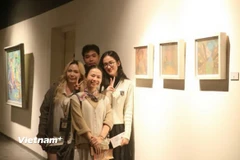 Bạn Võ Đình Lân và Vũ Yến Nhi, Ban Tổ chức triển lãm “Nữ Thời” chụp ảnh cùng 2 họa sỹ. (Nguồn: Vietnam+)