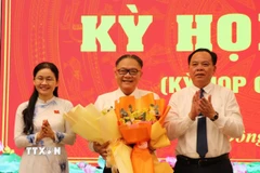 Phó Bí thư Thường trực Tỉnh ủy, Chủ tịch Hội đồng Nhân dân tỉnh Tôn Ngọc Hạnh và Chủ tịch Ủy ban Nhân dân tỉnh Võ Tấn Đức chúc mừng ông Nguyễn Kim Long được bầu giữ chức Phó Chủ tịch Ủy ban Nhân dân tỉnh. (Ảnh: Sỹ Tuyên/TTXVN)
