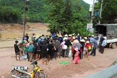 Người dân các bản còn cô lập nhận lương thực, thực phẩm, nhu yếu phẩm từ các hoạt động thiện nguyện tại bản Xiềng Tắm (xã Mỹ Lý, tỉnh Nghệ An) trước khi đưa xuống thuyền để chở về bản làng. (Ảnh: Xuân Tiến/TTXVN)