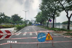 Lực lượng chức năng phong tỏa hiện trường vụ sụt lún trên đường Ba Đình. (Ảnh: Tiến Lực/TTXVN)