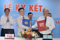 Ông Võ Khắc Thái (trái), Phó Chủ tịch Thường trực Liên đoàn Lao động Thành phố Hồ Chí Minh cùng ông Võ Hồng Tài, Quyền Tổng Giám đốc Công ty IPC (phải) thực hiện nghi thức ký kết hợp tác xây nhà ở xã hội. (Ảnh: Thanh Vũ/TTXVN)
