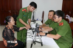 Phòng Cảnh sát Quản lý Hành chính về trật tự xã hội (PC06) Công an Thành phố Hồ Chí Minh thực hiện các thủ tục thu mẫu thu mẫu AND. (Ảnh: Thanh Vũ/TTXVN)