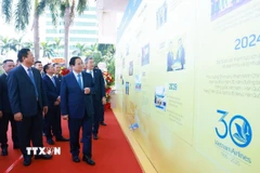 Thủ tướng Phạm Minh Chính tham quan trưng bày ảnh 30 năm thành lập Tổng Công ty Hàng không Việt Nam. (Ảnh: Dương Giang/TTXVN)