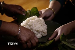 Xôi sau khi chín được quạt nguội rồi gói thành những gói nhỏ vuông vức bằng lá dong. (Ảnh: Trọng Đạt/ TTXVN)