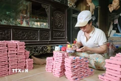 Trang trí tượng Tam vị Táo quân phù hợp thị hiếu khách hàng dịp Tết. (Ảnh: Võ Văn Dũng/TTXVN)