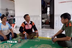 Ông Siu Un trao đổi với Công an cơ sở để vận động người dân từ bỏ tà đạo chung tay gìn giữ bình yên thôn, làng. (Ảnh: Hoài Nam/TTXVN)