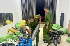 Lực lượng chức năng thu giữ các bình "khí cười". (Ảnh: TTXVN phát)
