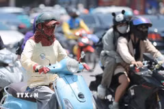Người dân khi ra đường cần trang bị khăn, mũ, áo chống nắng. (Ảnh: Minh Quyết/TTXVN)