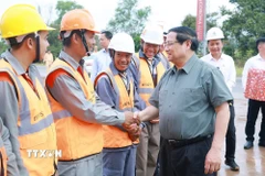 Thủ tướng Phạm Minh Chính với công nhân thi công dự án Đường tỉnh ĐT.975 (đoạn từ ĐT 973 - Cảng Hàng không Phú Quốc). (Ảnh: Dương Giang/TTXVN)