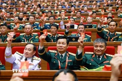 Đại biểu biểu quyết thông qua Nghị quyết Đại hội XIV của Đảng. (Ảnh: TTXVN)